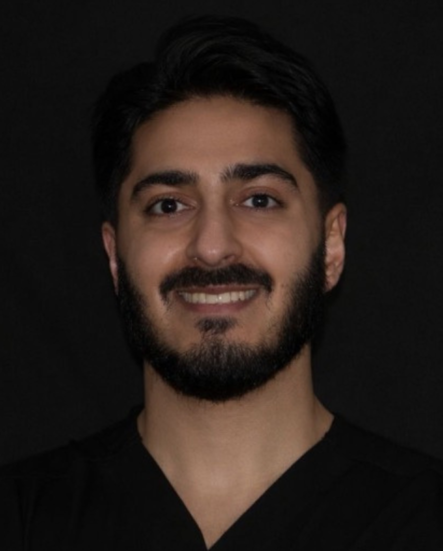 Dr Hamza Mirza, Associate Dentist at Sale Dental Spa, smiling in the practice — providing Invisalign, composite bonding, and teeth whitening treatments in Sale, South Manchester.