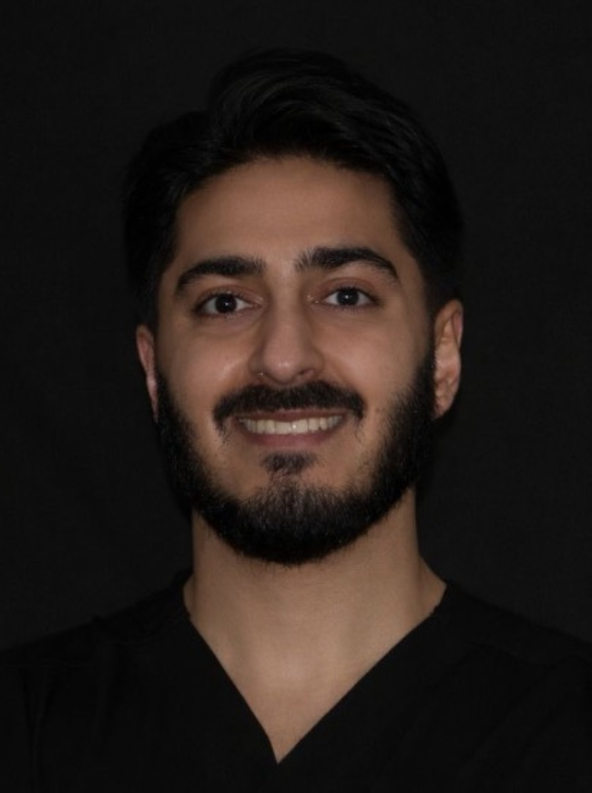Dr Hamza Mirza, Associate Dentist at Sale Dental Spa, smiling in the practice — providing Invisalign, composite bonding, and teeth whitening treatments in Sale, South Manchester.