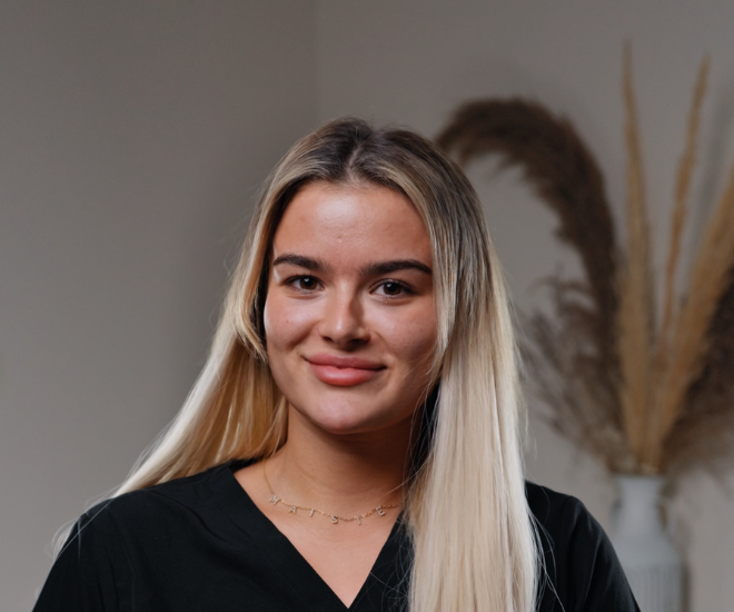 Maisie, Dental Nurse and Front of House at Sale Dental Spa, smiling at reception — welcoming patients to the leading cosmetic dental practice in Sale, South Manchester.