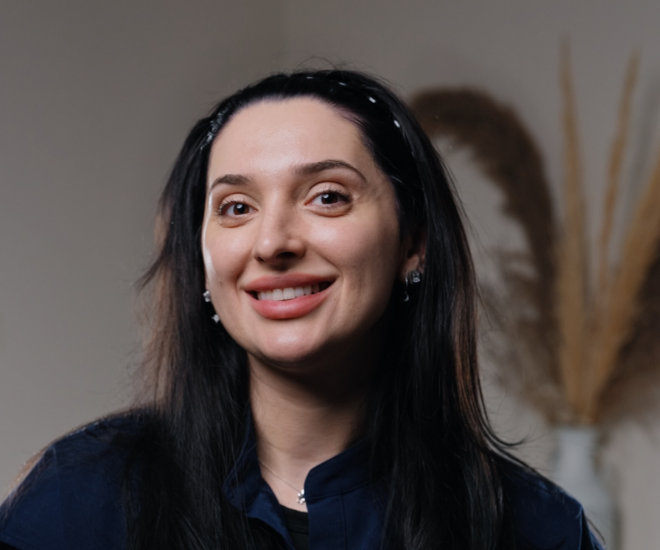 Cristina, Head of Front of House at Sale Dental Spa, smiling at reception — ensuring every patient enjoys a warm, seamless experience at the leading cosmetic dental practice in Sale, South Manchester.