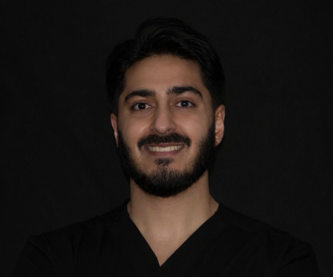 Dr Hamza Mirza, Associate Dentist at Sale Dental Spa, smiling in the practice — providing Invisalign, composite bonding, and teeth whitening treatments in Sale, South Manchester.