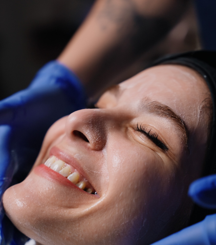 Yalda receiving a relaxing facial treatment and smiling at South Manchester cosmetic dental spa